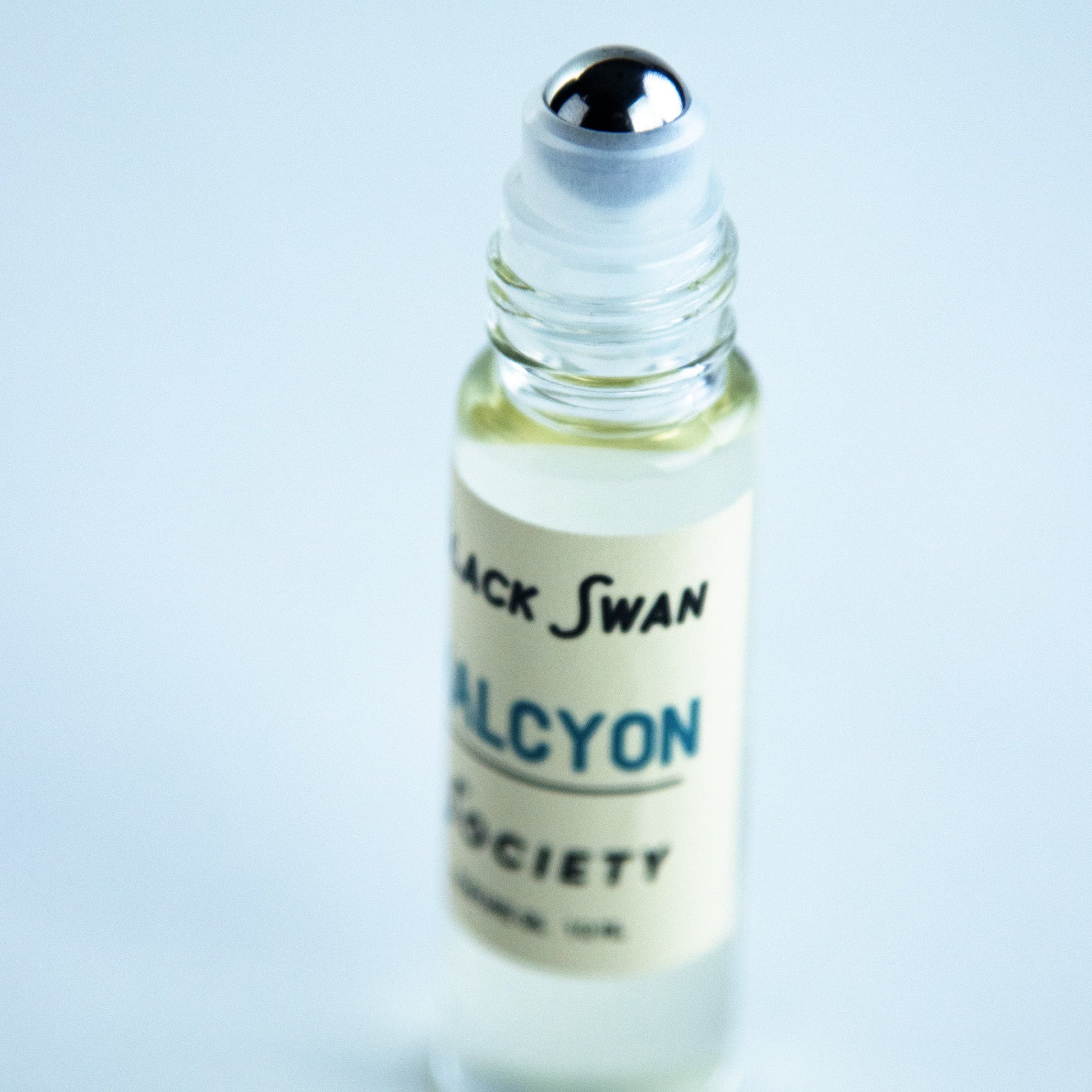 Perfume Oil Rollerball bottle with the roller exposed with the label Black Swan Society Halcyon 10ml