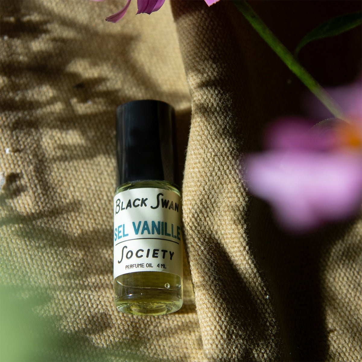 4ml Sel Vanille perfume oil rollerball bottle on it's side laying on a canvas bag.